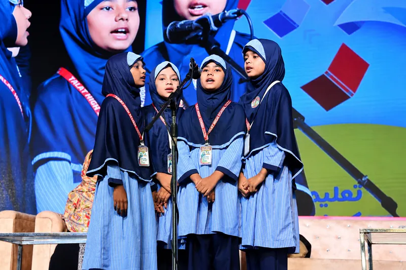 Schoolgirls Singing Beneath a Vivid LED Backdrop